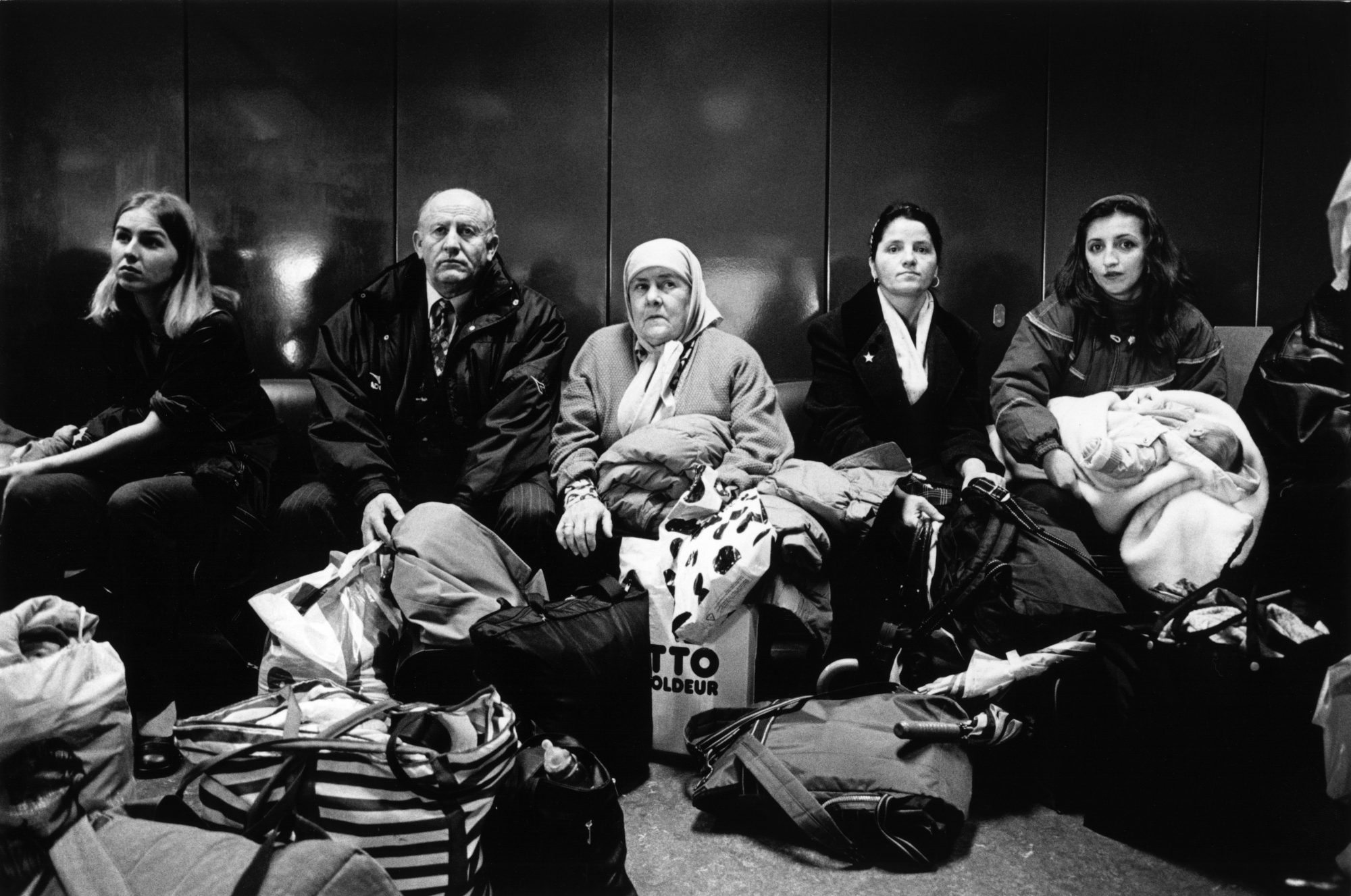 Zurich Airport, Switzerland 10/1999
©2000 Meinrad Schade / Lookat
www.lookat.ch

Borders
War refugees from Kosovo-Albania waiting for their flight to Skopje. They are returning voluntarily although their permit to remain in Switzerland does not expire for another seven months and they will face a bitingly cold winter on their return to Kososva